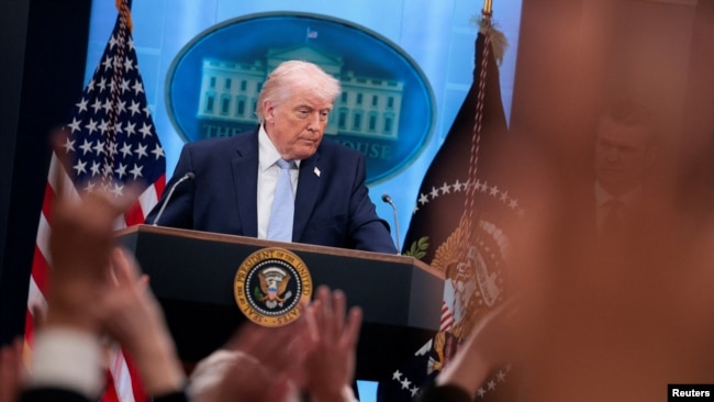 Tramp Ağ evin brifinq otağında mətbuat konfransı keçirir.